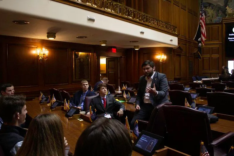 Kyle Pierce talking with students on the floor of the Indiana House chamber