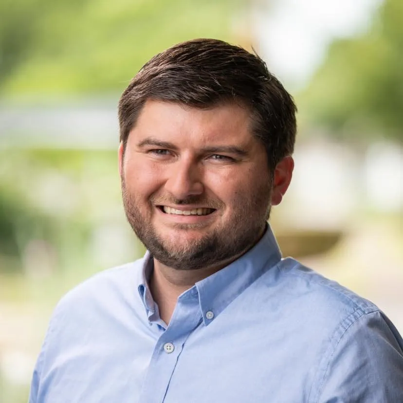 Kyle Pierce outdoors in a blue shirt, smiling